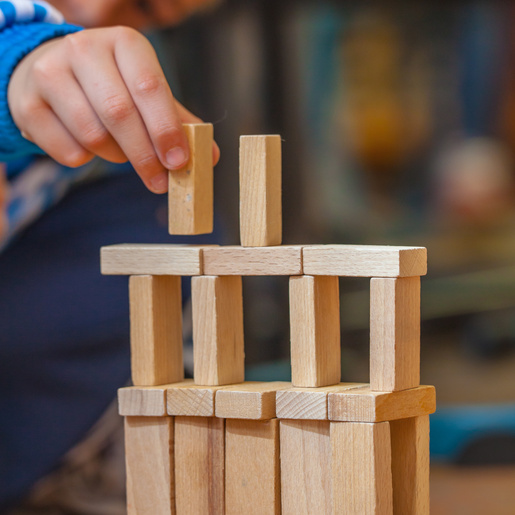 Boy putting Wooden Building Block on a Constuction